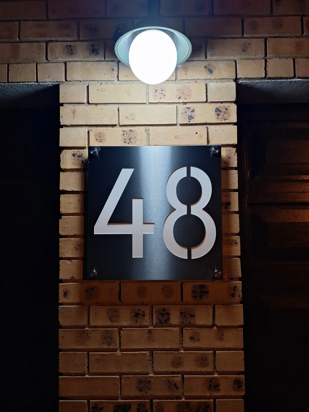RevID stainless steel address sign installed on a wall